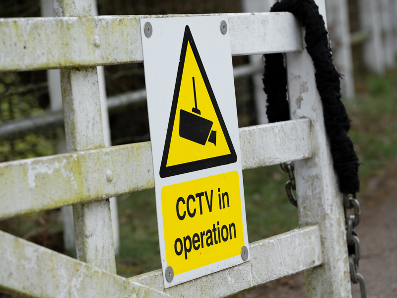 Farm gate with a CCTV sign